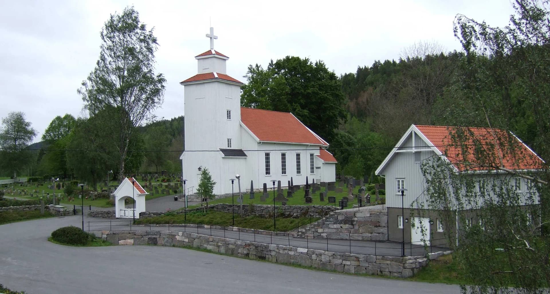 Froland kirke — den hvite trekirken med kirkegården rundt