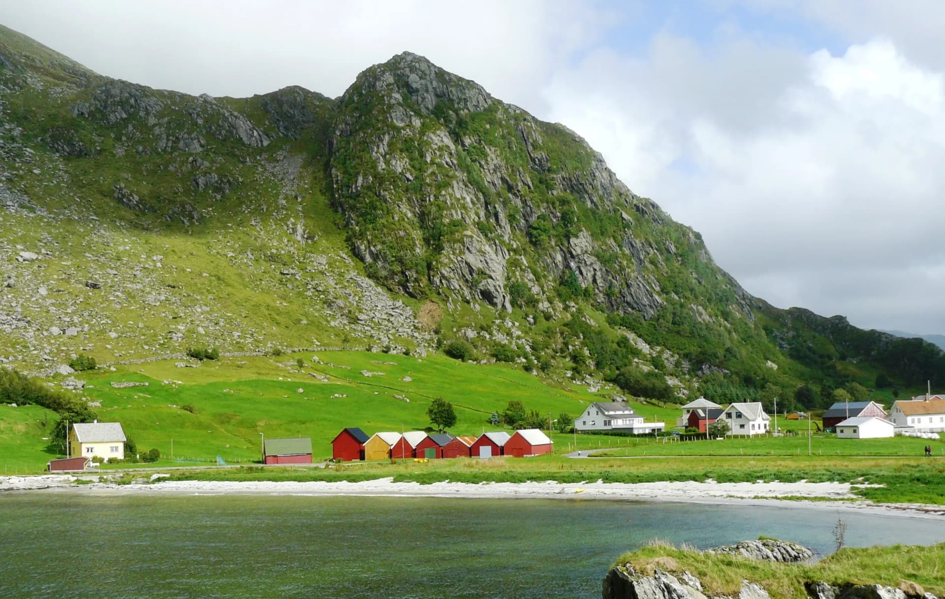 Grotlesanden i Bremanger — hvit sandstrand med røde naust under fjellet