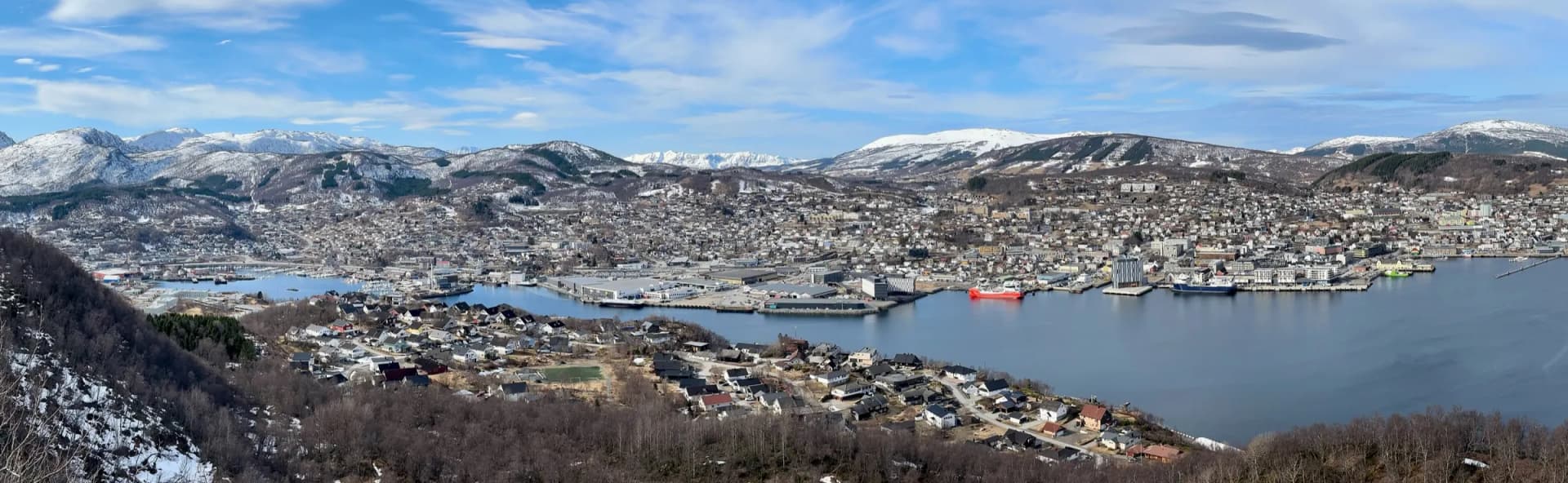 Panorama over Harstad fra Gangsåstoppen med havna og snødekte fjell