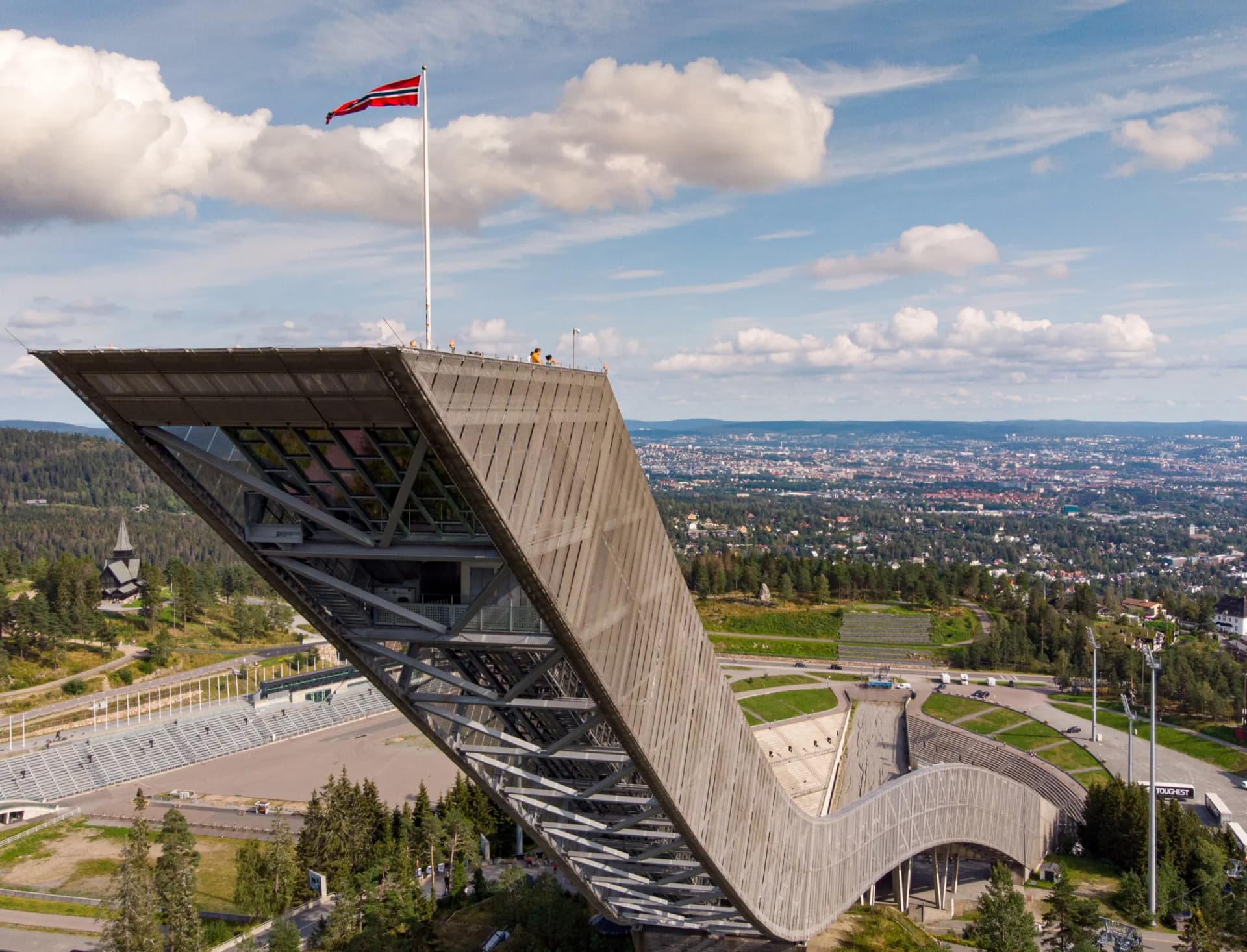 Holmenkollbakken med norsk flagg og utsikt over Oslo