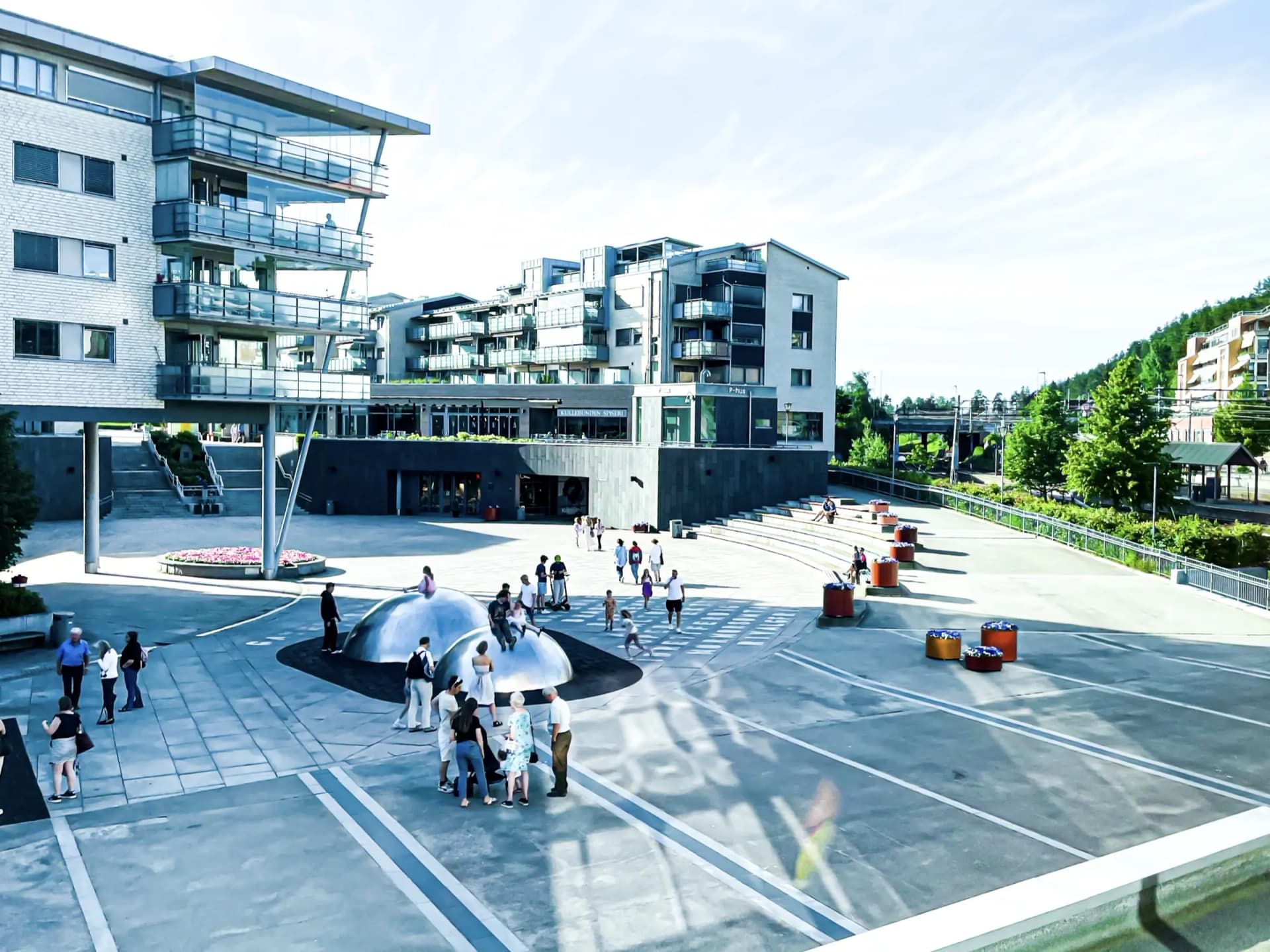 Kolbotn torg i Nordre Follo en sommerdag, med moderne leilighetsbygg