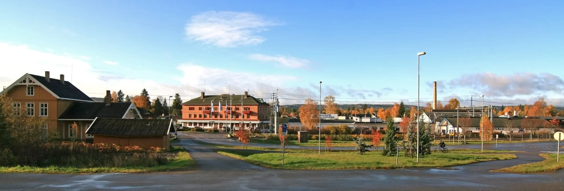 Magnor i Eidskog en høstdag, med jernbanestasjonen og glassverkspipa
