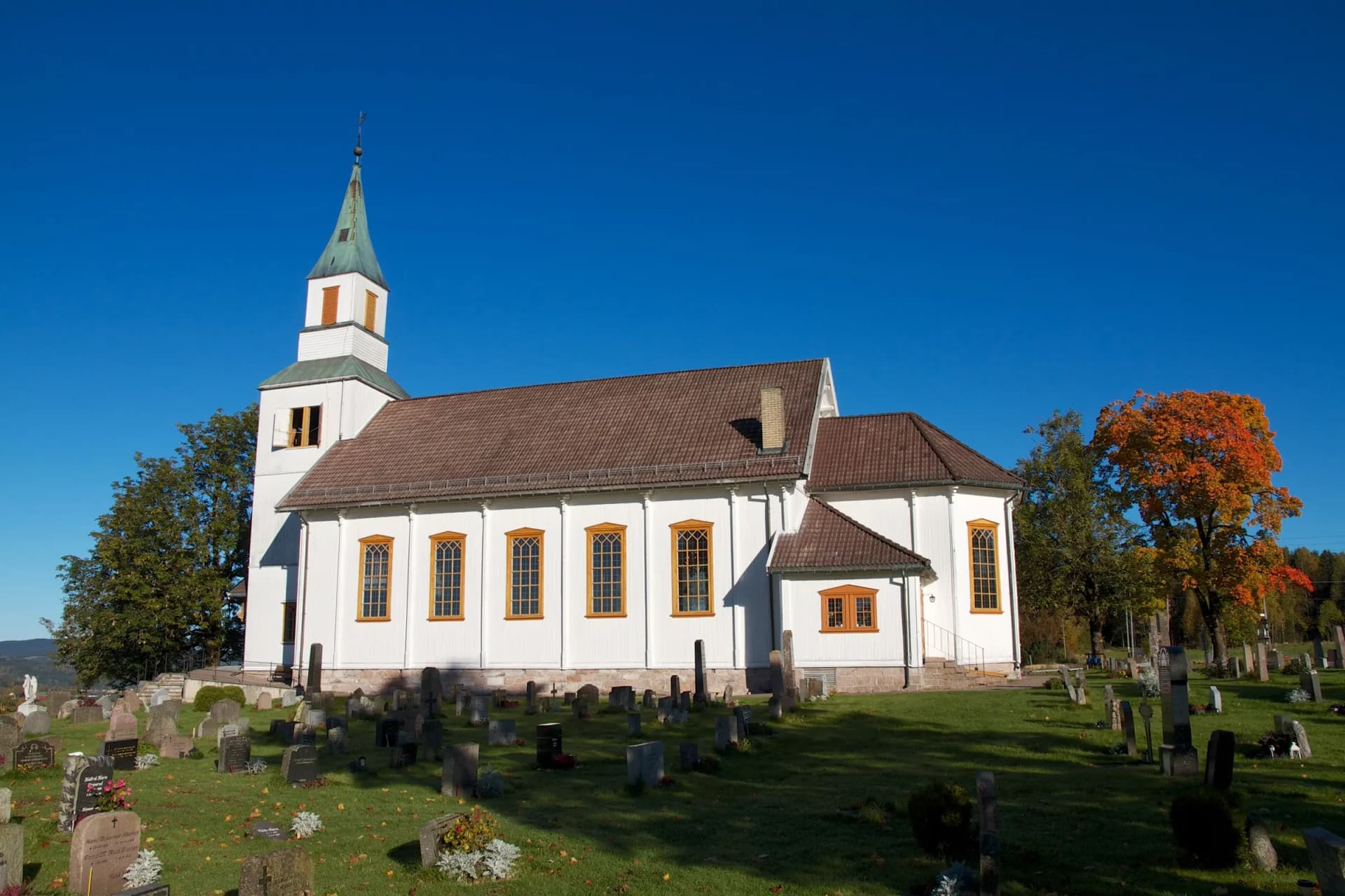 Nittedal kirke en klar høstdag med høstfarger i trærne