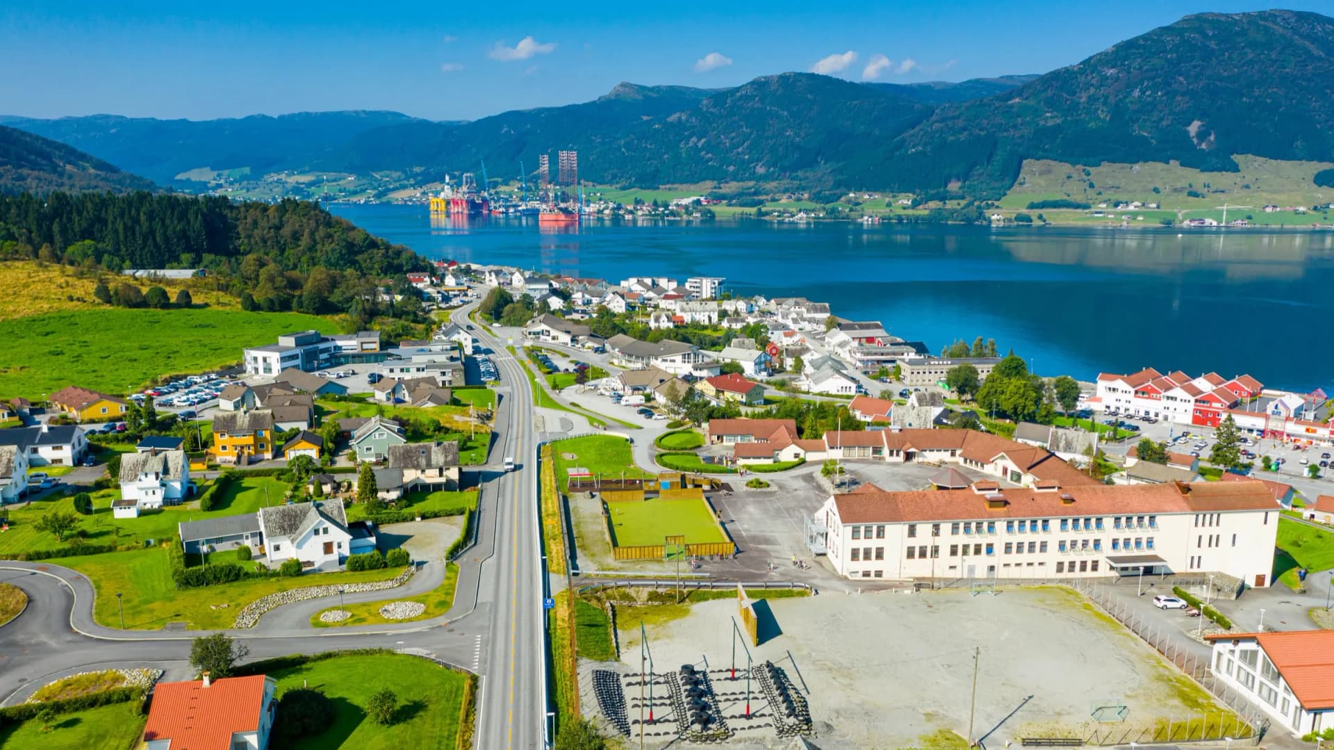 Ølen i Vindafjord sett fra lufta, med fjorden og fjellene bak