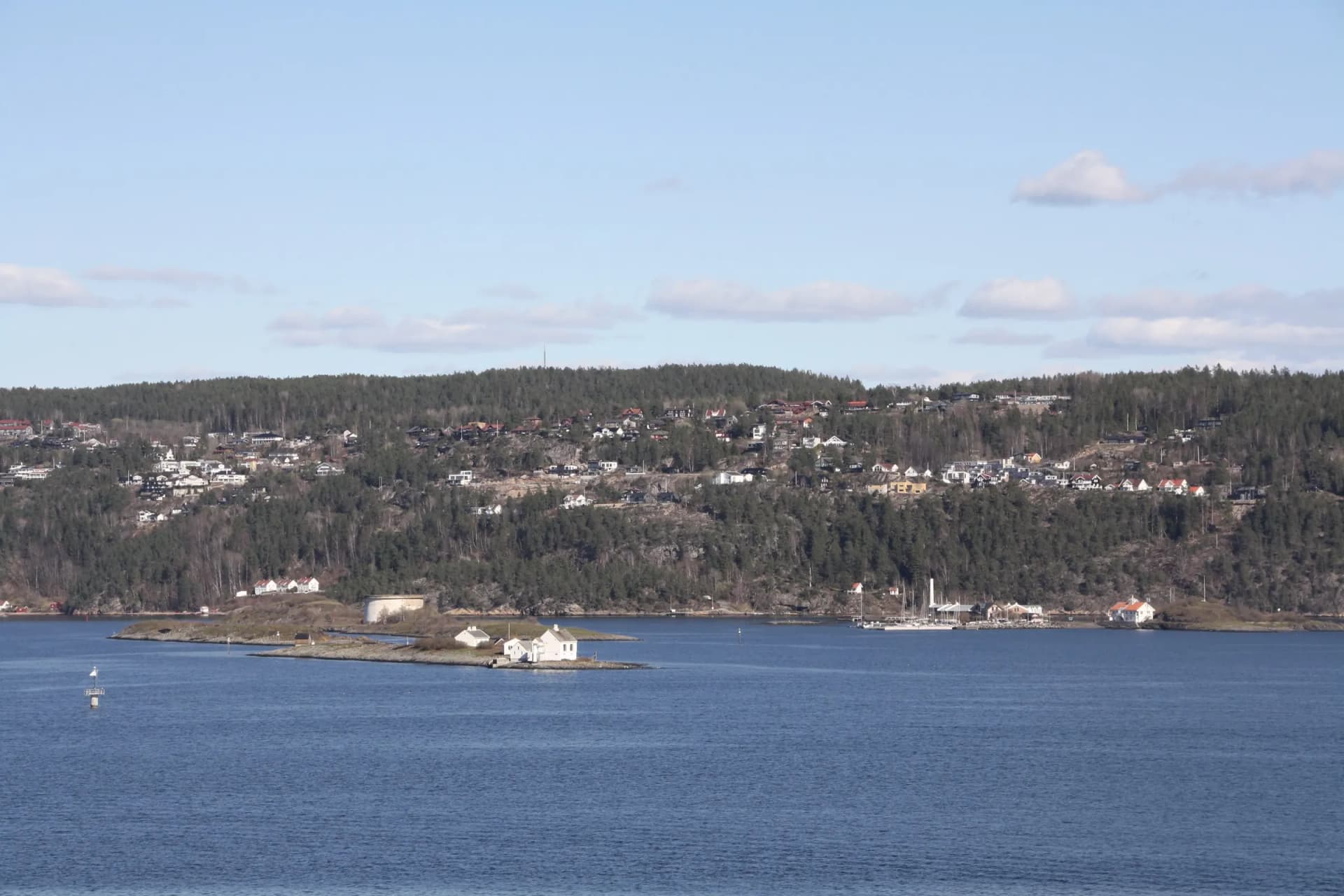 Nesoddlandet sett fra Oslofjorden med boliger i åssiden og holmer i forgrunnen