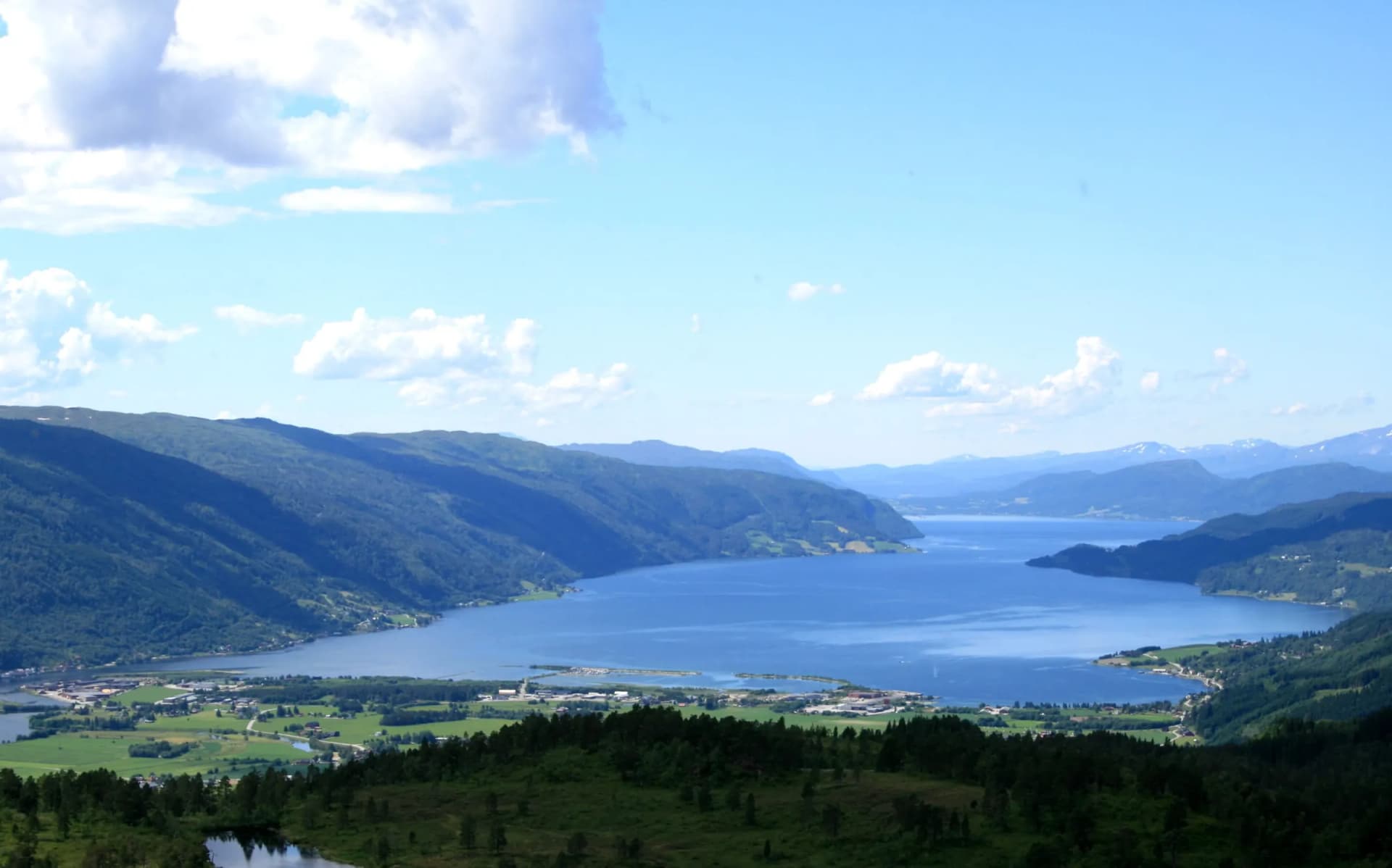 Utsikt over Surnadalsfjorden med bygda og grønne lier i solskinn