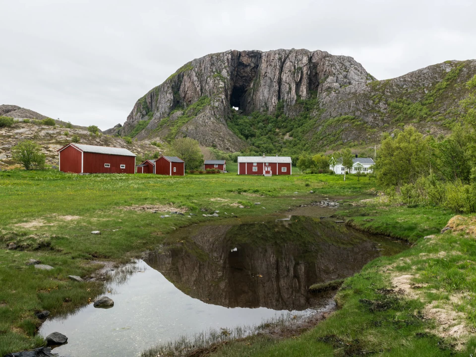 Torghatten i Brønnøy — fjellet med det karakteristiske hullet, med røde naust foran
